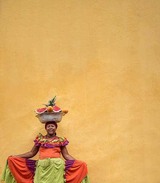 Beautiful Palenquera selling fruits in Cartagena and looking at the camera smiling