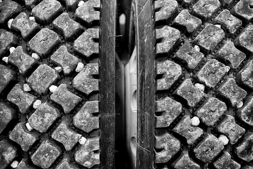 Close up of rocks stuck in industrial size truck tire treads