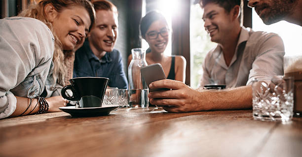 istock Young friends watching photos on mobile phone 626647352
