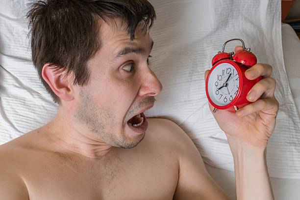 istock Frustrated, stressed man is waking up looking at alarm clock. 626648040