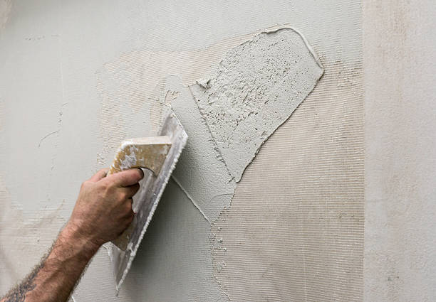 istock Hand holding a trowel, applying microcement thick preparation layer wallcovering 626648556