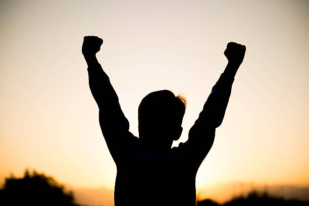 Rear view of a little boy cheering in happiness. Boy cheers with positive emotion. Horizontal composiiton. Image taken with Nikon D800 and developed from Raw format.
