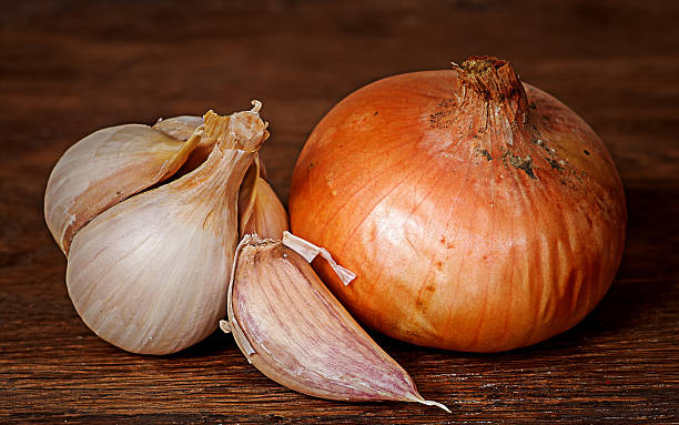istock Onion and garlic on wooden table 626666622