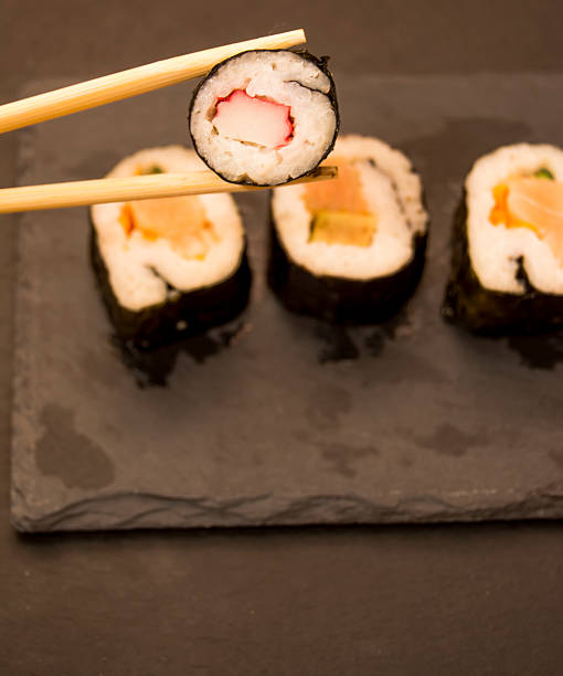 istock Pieces of sushi on a black stone 626667900