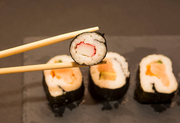 istock Pieces of sushi on a black stone 626668112
