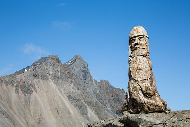 Wood Viking Sculpture and Rocky Peak This 5 foot tall wooden idol represents ancient nordic style, standing guard in Eastern Iceland among the craggy peaks viking ship photos stock pictures, royalty-free photos & images