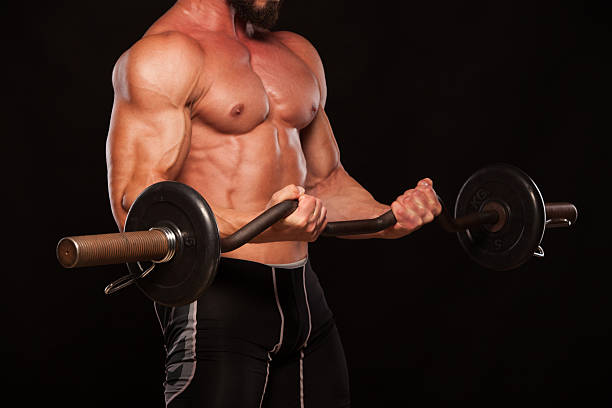 istock Muscular male athlete is training by lifting the barbell 626670004