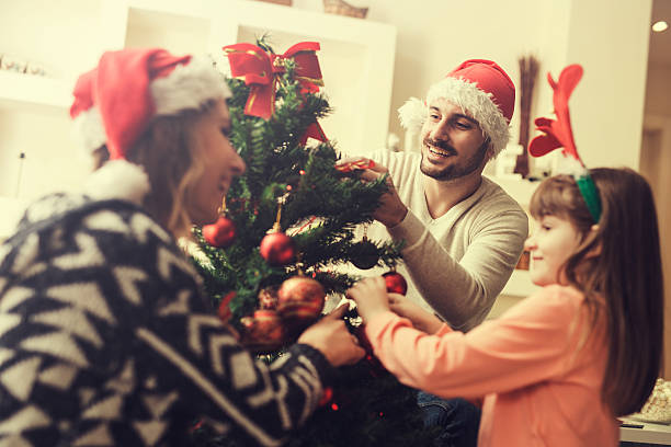 istock Happy family decorating a Christmas tree 626670458