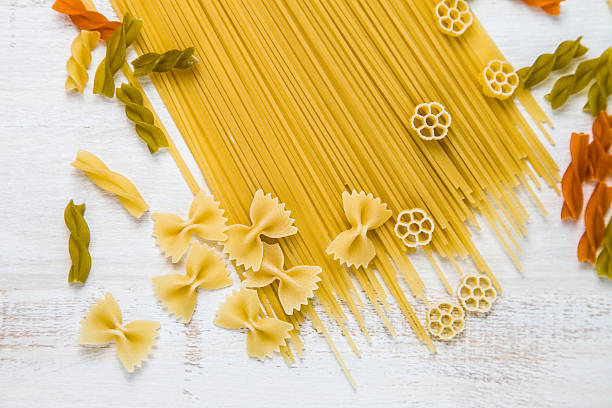 istock Raw pasta and spices on a wooden table 626672268