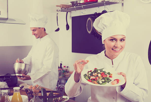 istock Smiling female young cook holding plate 626672934