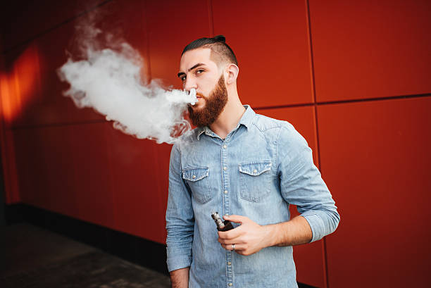 vaping. men with beard vaping electronic cigarette outdoor. - one person looking at camera male posing imagens e fotografias de stock