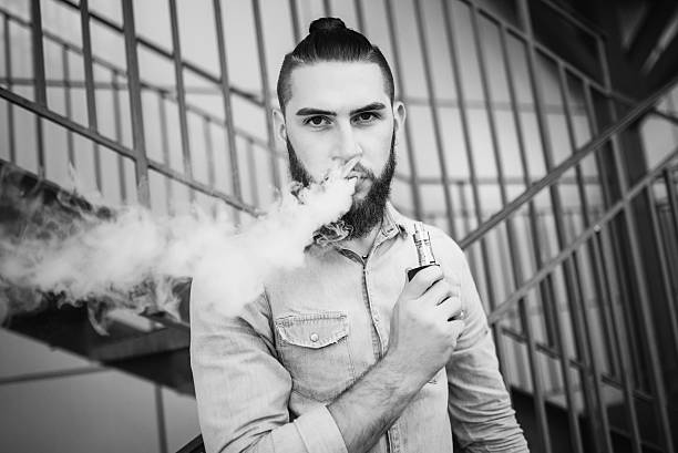 portrait of vaper vaping a vaporizer outdoors. safe smoking. - one person looking at camera male posing imagens e fotografias de stock