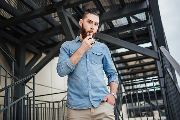 vaping. men with beard vaping electronic cigarette outdoor. - one person looking at camera male posing imagens e fotografias de stock