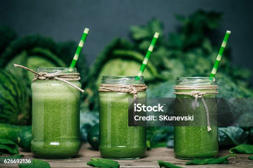 istock Blended green smoothie with ingredients on wooden table 626692136