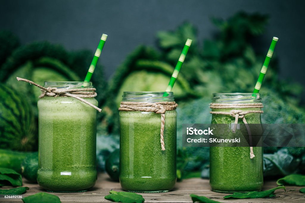 Blended green smoothie with ingredients on wooden table Smoothie Stock Photo