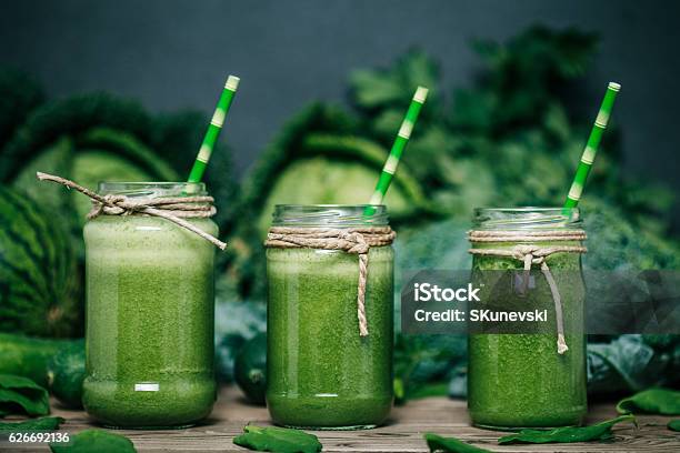 Blended Green Smoothie With Ingredients On Wooden Table Stock Photo - Download Image Now