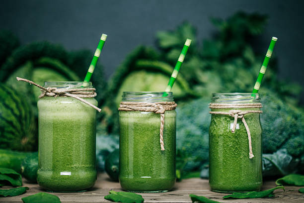 смешанные зеленые смузи с продукты на деревянном столе - kale стоковые фото и изображения