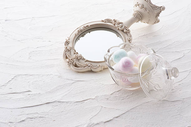 istock Mirror and cotton balls in a jar on white background 626692140