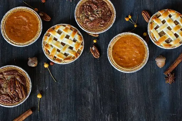 Overhead view of three mini  pies - apple pie pumpkin pie and pecan pie / Thanksgiving Desserts