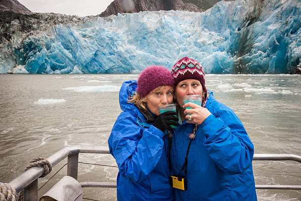 Glacier margaritas in Alaska Two blond sisters drink a glacier margarita on the deck of a cruise ship at North  Sawyer Glacier, Tracy Arm Fjord, Juneau, Alaska cruise ship people stock pictures, royalty-free photos & images