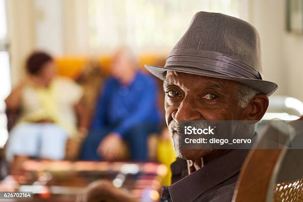 Photo libre de droit de Homme Noir Senior Avec Chapeau Regardant La Caméra Dans Un Hospice banque d'images et plus d'images libres de droit de Troisième âge