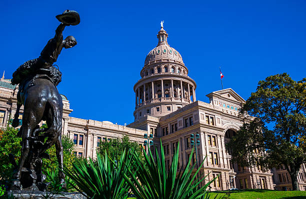 Texas State Capitol Building Cowyboy Austin Texas Texas State Capitol Building Cowyboy statue in central texas Austin Texas USA desert plants , Texas flag and American Flag , amazing Capitol building capital cities stock pictures, royalty-free photos & images