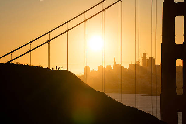 мост золотые ворота и центр сан-франциско на восходе солнца - sun lighting equipment san francisco county downtown district стоковые фото и изображения