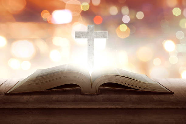 istock Open holy bible with wooden cross in the middle 626707932