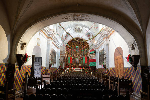 Interior of San Xavier Mission in Tucson Interior of San Xavier Mission with Christmas decoration, Tucson, Arizona, USA. San Xavier Mission is a Catholic mission founded in 1692. It is a national historic landmark located 9 miles south of downtown Tucson. The mission 's interior is filled with original statues and mural paintings of 18th century. It is a popular tourist destination. tucson christmas stock pictures, royalty-free photos & images