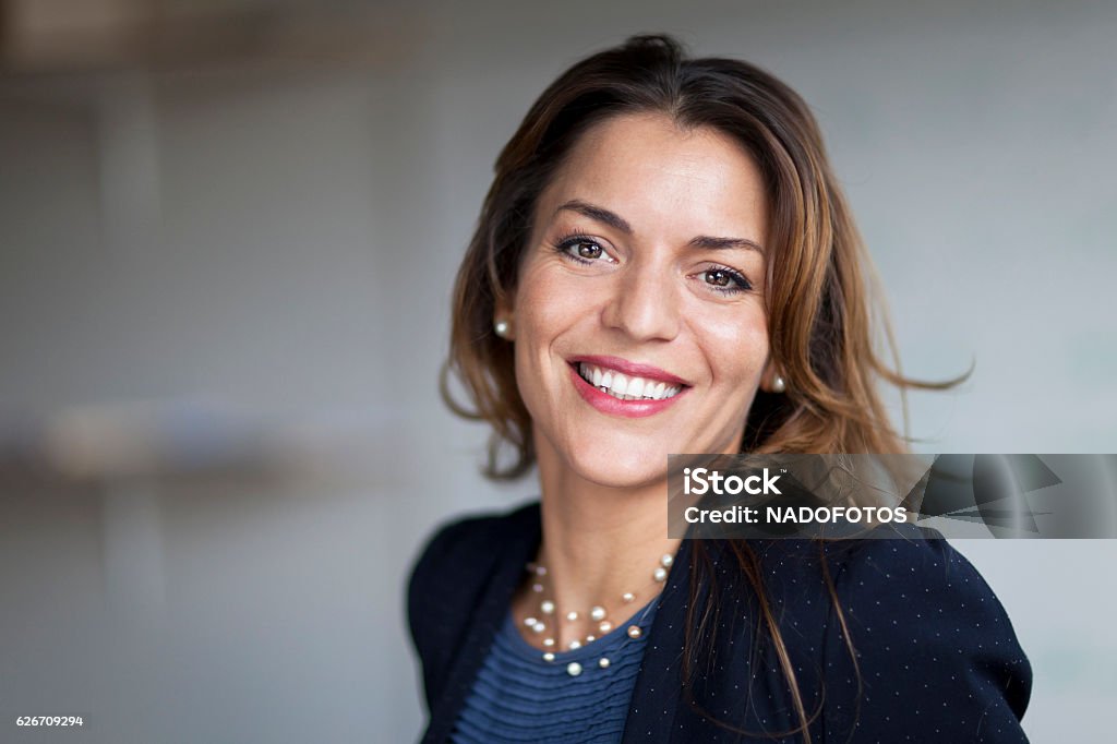 Empresária espanhola sorrindo para a câmera. No escritório. - Foto de stock de Mulheres royalty-free