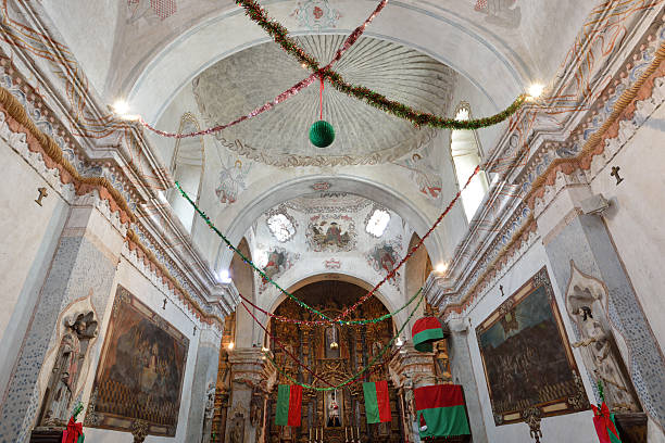 Interior of San Xavier Mission in Tucson Interior of San Xavier Mission with Christmas decoration, Tucson, Arizona, USA. San Xavier Mission is a Catholic mission founded in 1692. It is a national historic landmark located 9 miles south of downtown Tucson. The mission 's interior is filled with original statues and mural paintings of 18th century. It is a popular tourist destination. tucson christmas stock pictures, royalty-free photos & images