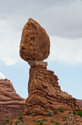 Balanced Rock in the Windows section of Arches National Park stands precipitously balanced on a sandstone ledge.