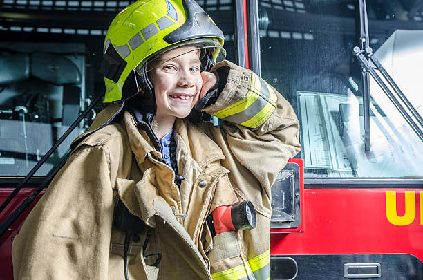 istock Young boy wearing fireman coat and helmet 626723980