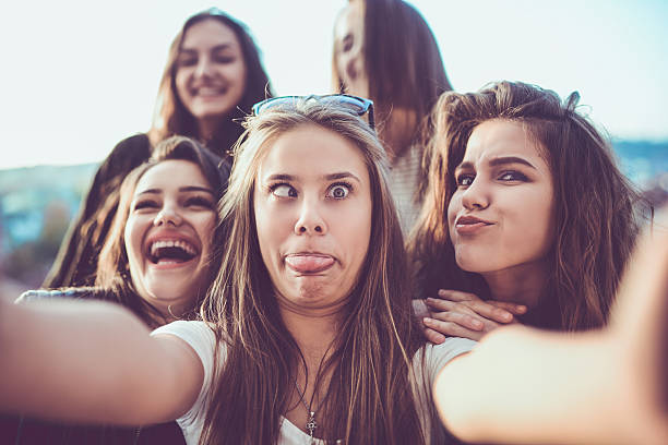 grupo de chicas locas tomando selfie y haciendo caras al aire libre - poner caras fotografías e imágenes de stock