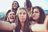 Group of Crazy Girls Taking Selfie and Making Faces Outdoors