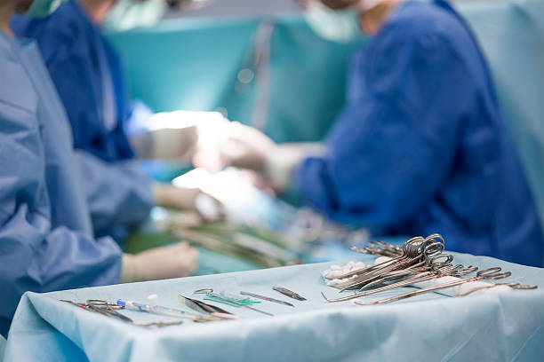 chirurgische instrumente auf dem tisch während der operation - medizinischer vorgang stock-fotos und bilder