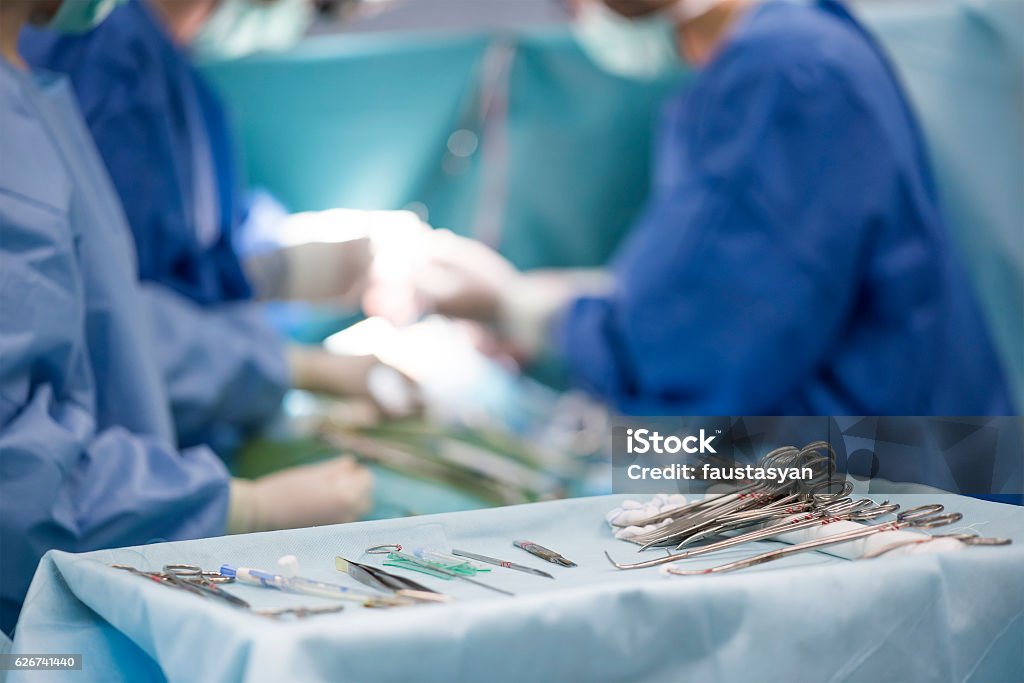 surgical instruments on the table during surgery sterile surgical instruments on during the operation table amid the surgeons Surgery Stock Photo