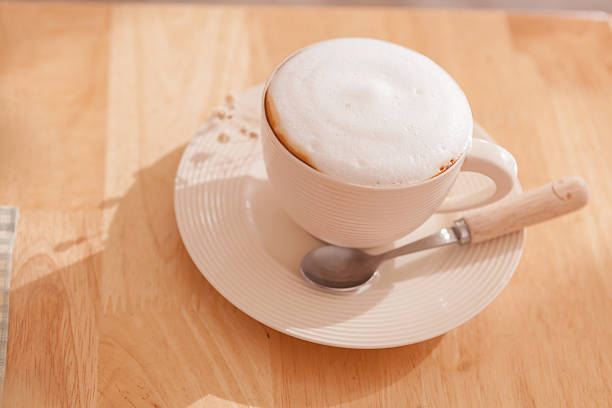 Cup of coffee cappuccino art on wooden table vintage or retro style