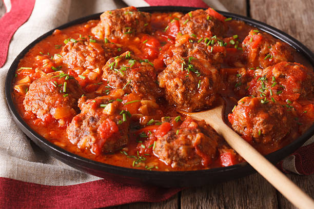 Meatballs with spicy tomato sauce on a dish on the table close-up. horizontal