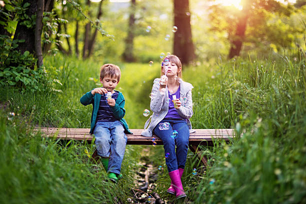 istock Kids blowing bubbles on the bridge in the springtime 626753142