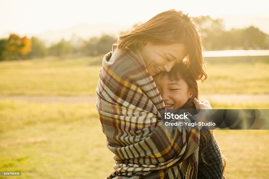 Mother hugging daughter in outdoors Mother and daughter having fun time in outdoors Embracing Stock Photo