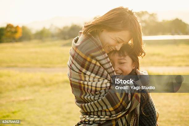 Mother Hugging Daughter In Outdoors Stock Photo - Download Image Now - Embracing, Hope - Concept, Japanese Ethnicity