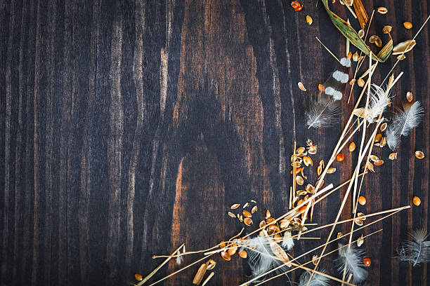 istock Wooden background with hay, feathers and grains millet. 626771320