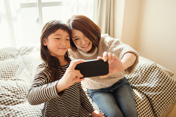 istock Mother and daughter taking a selfie in bed room 626771340