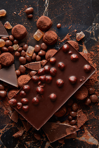 Assortment of delicious chocolate and candies on dark background, close up