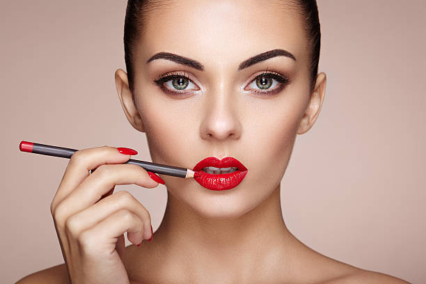 istock Beautiful woman paints lips with lipstick 626771948
