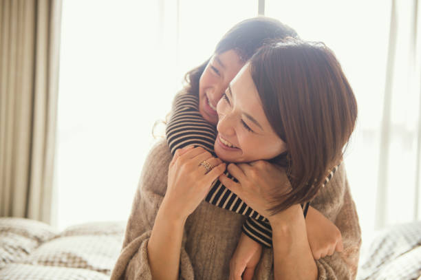 Mother and daughter playing in bed room Mother and daughter having fun time in bed room kinki region photos stock pictures, royalty-free photos & images