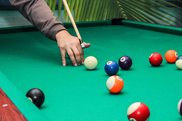 istock Billiard balls on green table and hand with cue 626775166