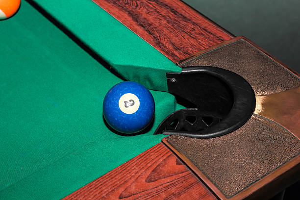istock Billiard balls on green table and blue ball in pocket 626775298