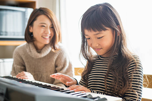 istock Mother and daughter playing  on electronic piano 626776468